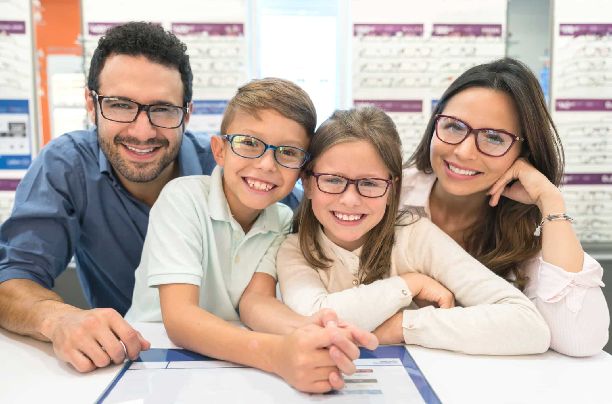 Happy family trying on glasses at the optical shop Comprehensive Eye Exam Dallas TX